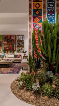 a living room filled with lots of furniture and plants in front of a colorful wall