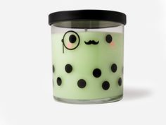 a green candle with black polka dots and a mustache on the top, sitting in front of a white background