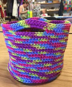 a colorful basket sitting on top of a wooden table