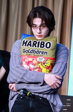 a young man is holding a pillow that says harbo goldfren