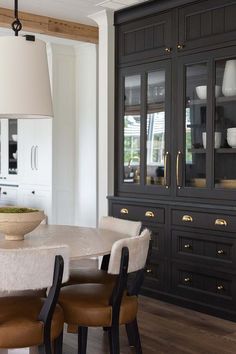 the dining room table is surrounded by black cabinets