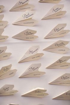 paper airplanes are lined up on a white surface with japanese writing in the middle and below them