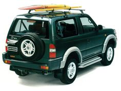 a black truck with a surfboard on top of it's roof rack in front of a white background