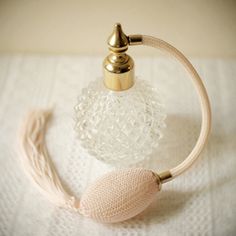 a white towel with a gold faucet on it and a glass bottle next to it