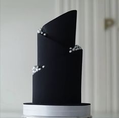 a black and white cake with pearls on it