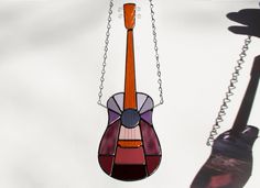 a stained glass guitar hanging from a chain