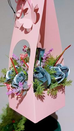 a pink paper bag with flowers in it