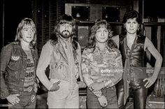 an old black and white photo of three men standing next to each other with their hands on their hips