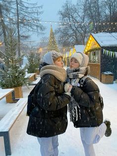 two women are standing in the snow together