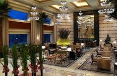 an elegant lobby with chandeliers and seating