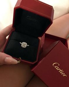 a woman is holding an engagement ring in her red box with the word couture written on it