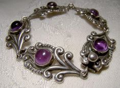 A Mexican sterling silver and amethyst cabochons bracelet circa 1930s 1940 This 7-3/8" x 5/8" wide bracelet is a classic Mexico design, and the 5 cabochon amethysts are genuine. This bracelet is stamped STERLING 925 TAXCO with a 3 in the eagle mark for Taxco. It weighs 18.2 grams and has a box clasp, and it is in excellent vintage condition with no  corrosion, losses, damage or repairs, but there is a small triangle shape gap on one amethyst. It does not appear to be damage, but an original aspect of the stone.    Jewelry will have signs of use. Expedited tracked parcel to the U.S. starts at $23.00 and expedited parcel within Canada starts at $17.00 (tracking and loss insurance is included).  At this time, we are required to choose a single postal rate, which may not be applicable to your Vintage Polished Cabochons For Formal Use, Vintage Amethyst Jewelry With Polished Finish, Vintage Purple Metal Bracelets, Antique Silver Cabochon Bracelets, Vintage Purple Bracelet For Formal Occasions, Vintage Silver Gemstone Bracelets, Vintage Sterling Silver Bracelet With Gemstone, Vintage Sterling Silver Cabochon Bracelets, Vintage Sterling Silver Bracelets With Cabochon