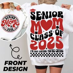 a woman wearing a white sweatshirt with the words senior mom class of 205 printed on it