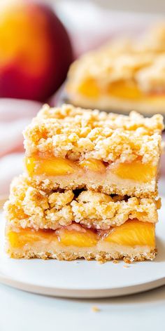 two pieces of peach pie on a white plate with an apple in the back ground