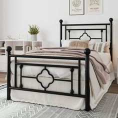 a black metal bed frame in a white bedroom