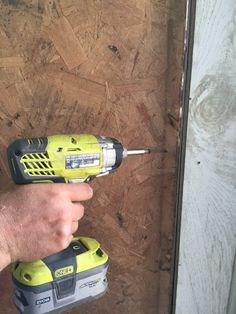 a man is holding a drill in his hand