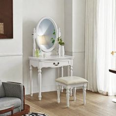 a white dressing table with a mirror and stool in a living room next to a window