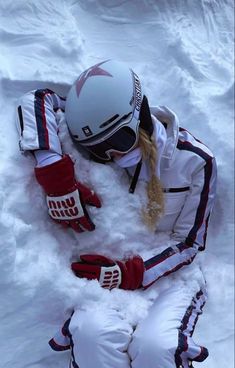 a person laying in the snow wearing skis