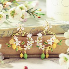 Brighten up your style with our Lemon Garland Earrings! These delightful accessories capture the freshness of a garden and the carefree spirit of a vacation. Crafted with meticulous detail, each earring showcases a cluster of vibrant lemons, creating a playful and joyful look. Elevate your ensemble with this cheerful and nature-inspired accessory. 🍋🌿🌞 DETAILS Plating: 18K Gold  Materials: 18K Gold on Brass,   Enamel, Cubic Zirconia Size: 1.69"* 1.22 "(4.3cm*3.1cm) Weight:12.4g/pr Lemon Jewelry, Lemon Garland, Gift Wishlist, Pearl Gifts, Unique Gift Wrapping, Fruit Jewelry, Fruit Earrings, Luxe Jewelry, Butterfly Gifts