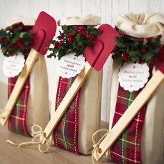 three christmas stockings with wooden sticks attached to them, tied together and sitting on a table