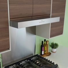 a stove top oven sitting inside of a kitchen next to a counter with bottles on it