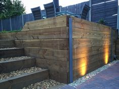 a wooden fence with steps leading up to it and some chairs on the other side