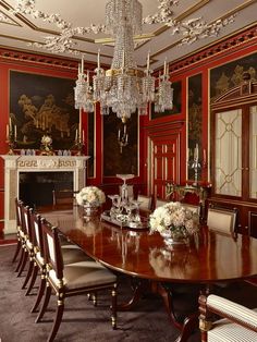 an elegant dining room with red walls and chandelier