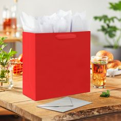 a red paper bag sitting on top of a wooden table