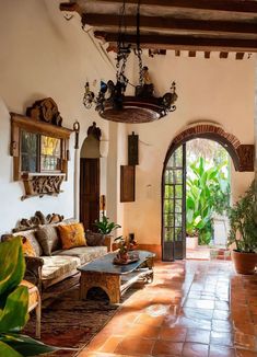 a living room filled with lots of furniture and plants on top of tiled flooring