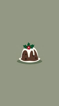 a christmas pudding with icing and holly on top, sitting on a green surface