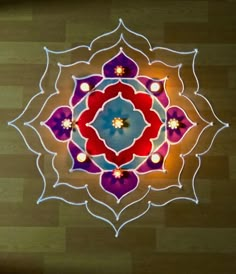 an overhead view of a colorful flower design on wood flooring with lights in the center