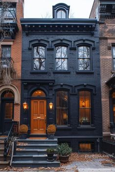 an old black house with stairs leading up to the front door and windows on each side