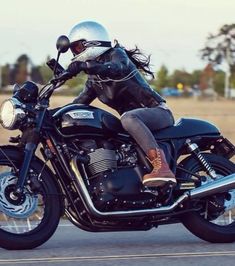 a woman riding on the back of a black motorcycle