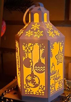 a lighted lantern with christmas decorations on it