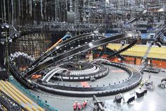 an overhead view of a train station with multiple tracks and people in the background looking down at it