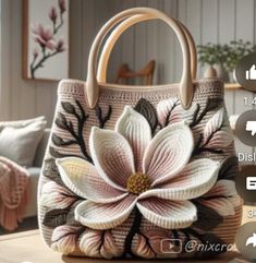 a handbag with flowers on it sitting on a table next to pillows and pictures