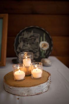 three candles are placed on top of a table