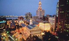 the city is lit up at night with lights on and buildings in the foreground