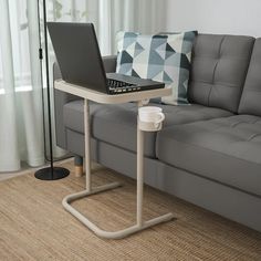 a living room with a couch, coffee table and laptop computer on it's stand