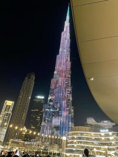 a very tall building towering over a city at night