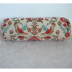 a white case with red and blue flowers on the front is sitting on carpeted floor