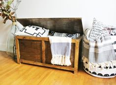 a wooden crate sitting on top of a hard wood floor next to a vase filled with flowers