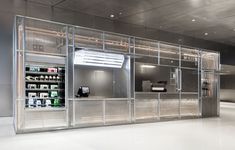 the inside of a store with glass doors and shelves filled with bottles, cans and other items