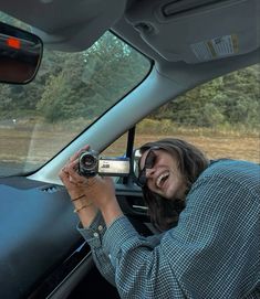 a woman taking a photo in the back seat of a car