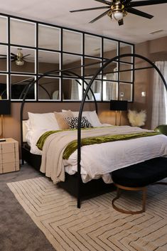 a bedroom with a large bed and mirrored walls