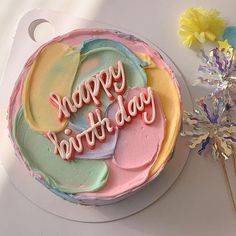 a birthday cake with the words happy birthday written on it next to a small flower