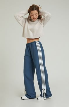 Step into athleisure vibes with the PacSun Wide Leg Track Pants. These trendy track pants combine comfort and style with a wide-leg silhouette, stripes down the leg, and ties at the ankles, offering a versatile and laid-back addition to your wardrobe, perfect for casual outings or cozy days at home.11.5" rise31.5" inseam23" leg openingHigh-riseElastic waistbandStripes down the legsTie detail at the ankleSide hand pocketsWide leg openingRelaxed fitRoomy through the hip and thigh62% cotton, 38% ny Retro Wide Leg Pants, Wide Leg Striped Pants, Relax Fit Pants, Popular Pants For Women, Wide Leg Workout Pants, Nike Blue Pants, Casual Bottom Wear For Women, Styling Track Pants Women, Athletic Streetwear Women