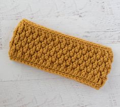 a yellow crochet headband laying on top of a white table