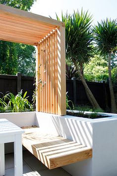 a wooden bench sitting next to a white table