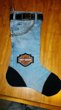 a pair of blue jeans with harley davidson patch on them sitting on top of a wooden table